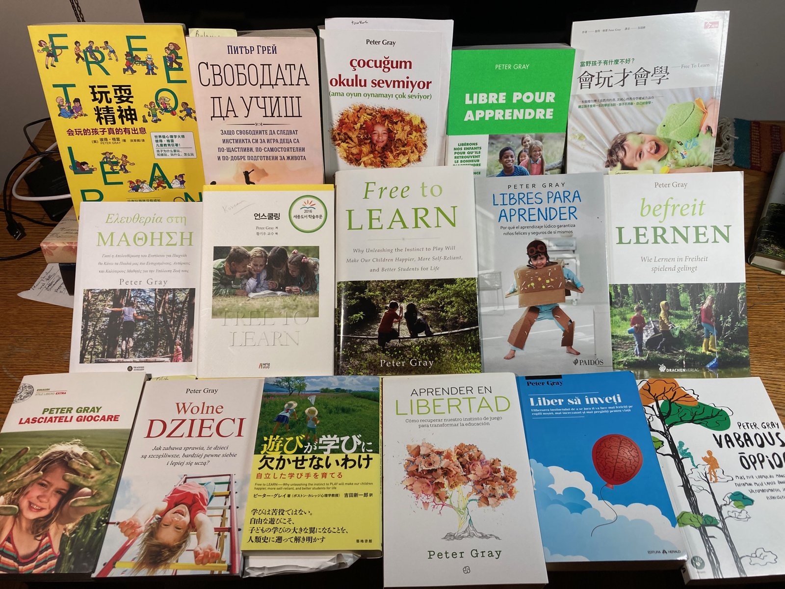 A table covered with copies of Free to Learn in more than a dozen languages, including Spanish, French, German, Polish, Greek, Japanese and Chinese editions
