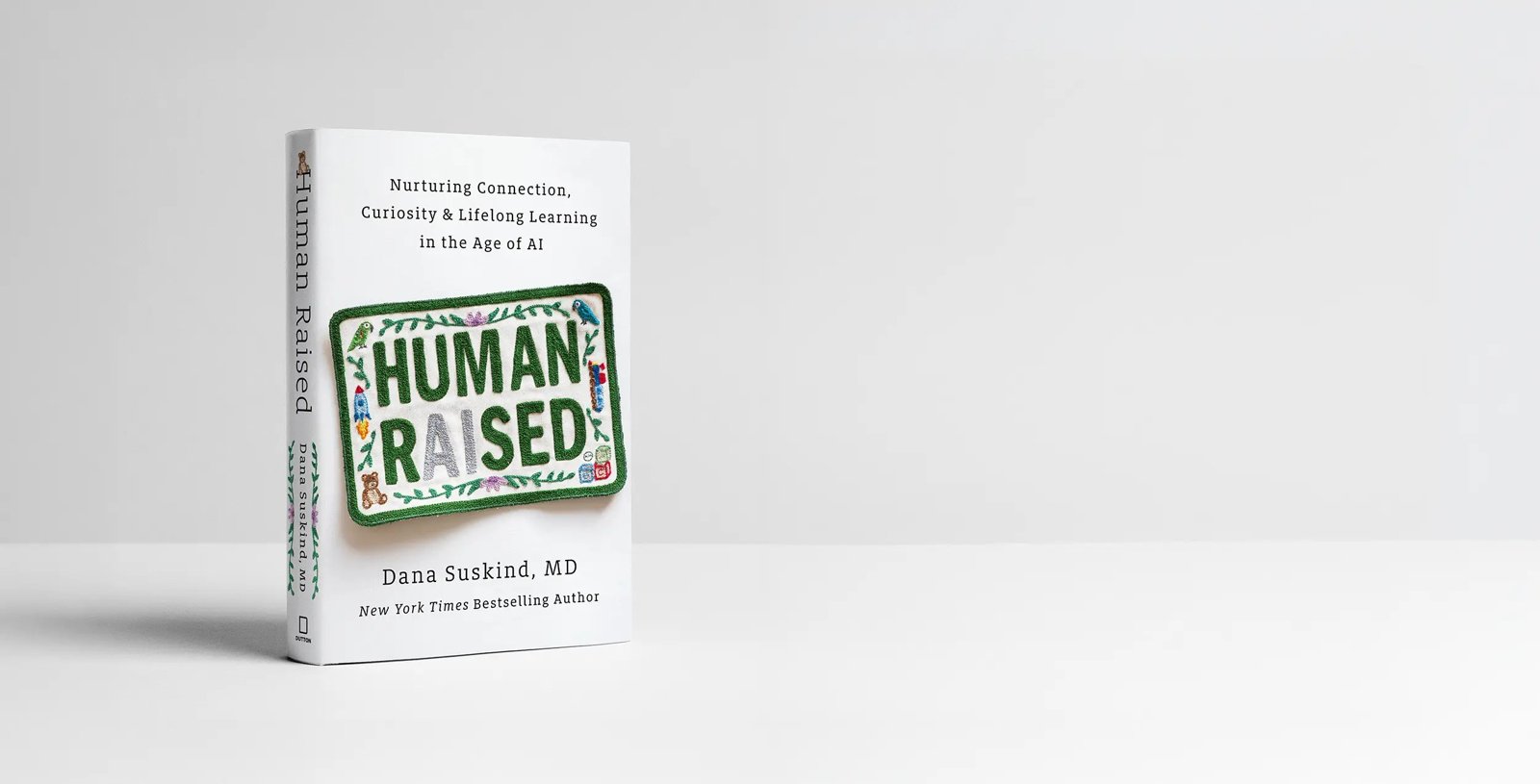 The book Human Raised standing upright on a white surface