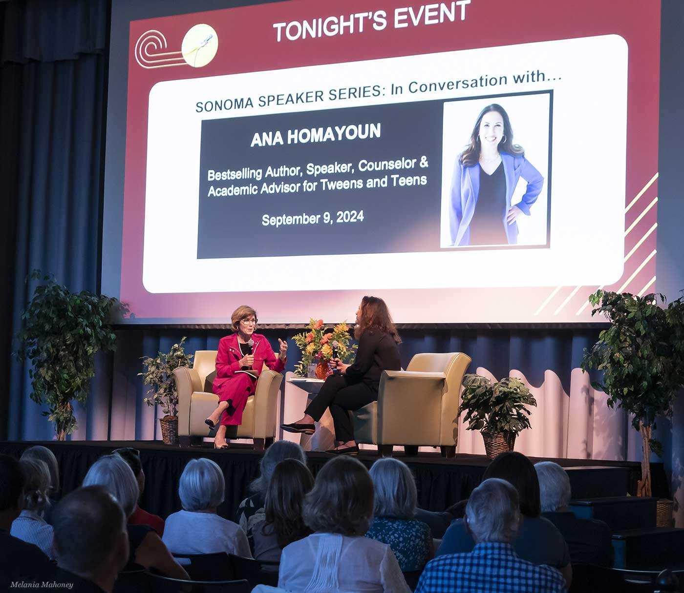 Ana Homayoun on stage at the Sonoma Speaker Series in September 2024, seated in conversation beneath a large screen showing her name