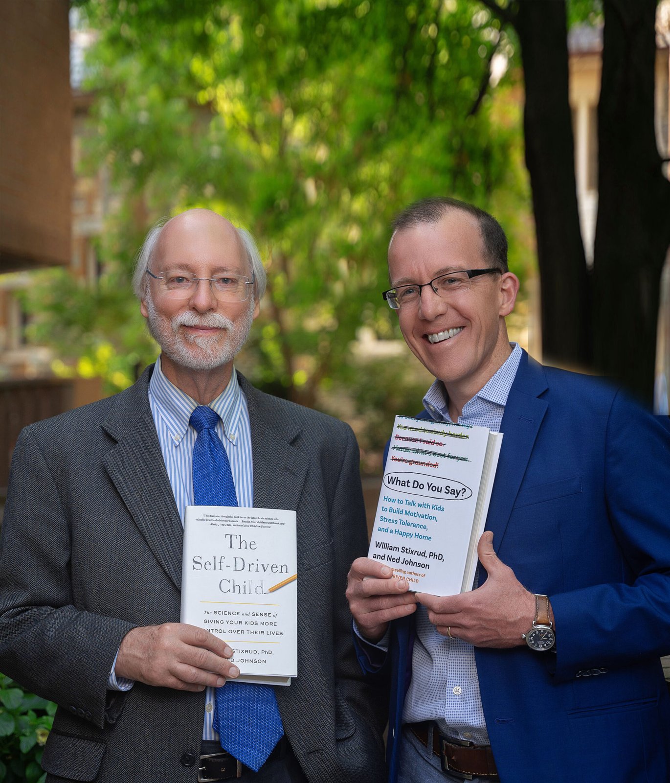 Bill Stixrud, older with a white beard and a blue tie, holding The Self-Driven Child, next to Ned Johnson in glasses and a blue blazer holding What Do You Say?, outdoors under trees